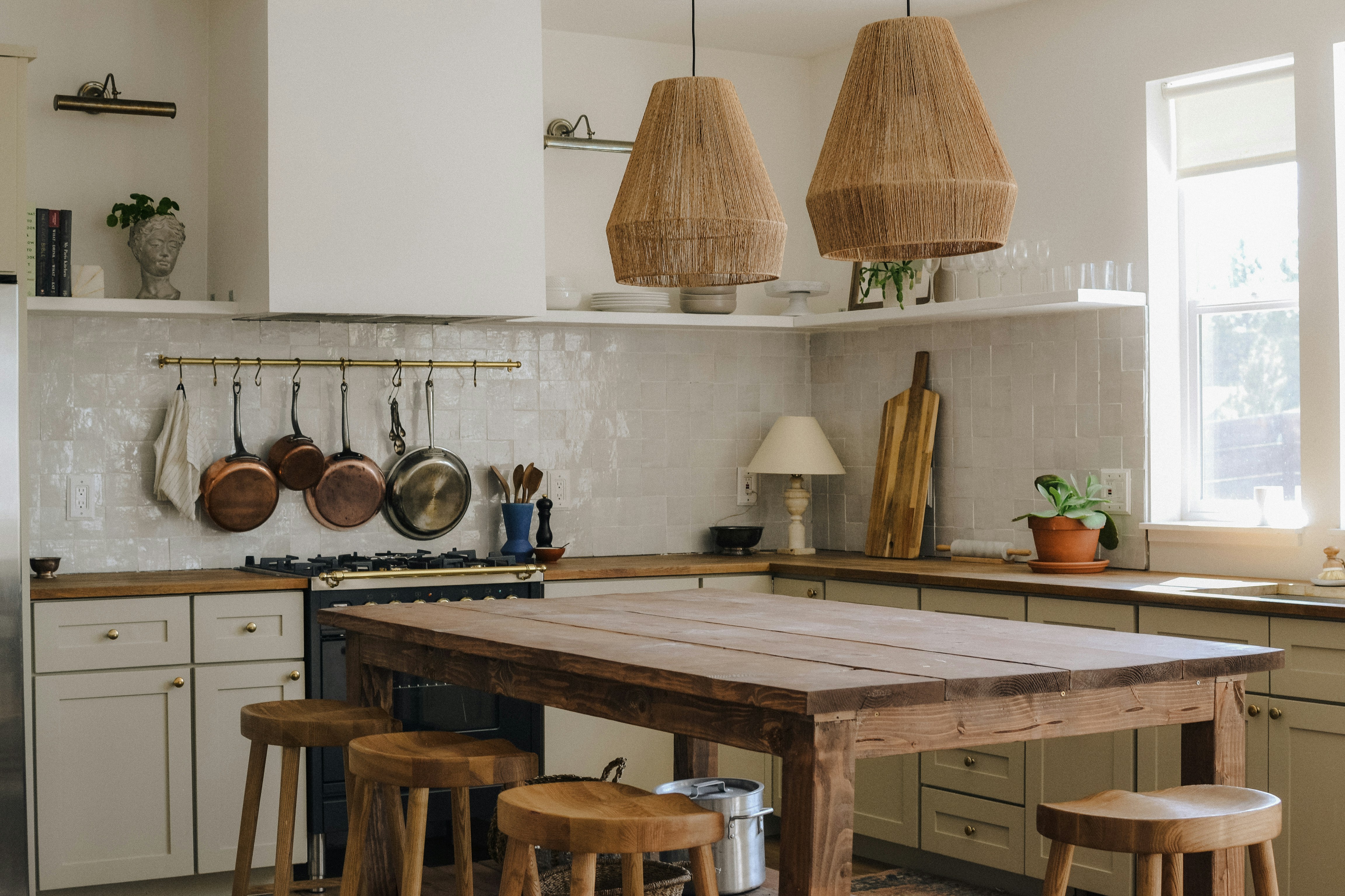 Warm, sunlit kitchen with copper pots and a wooden island